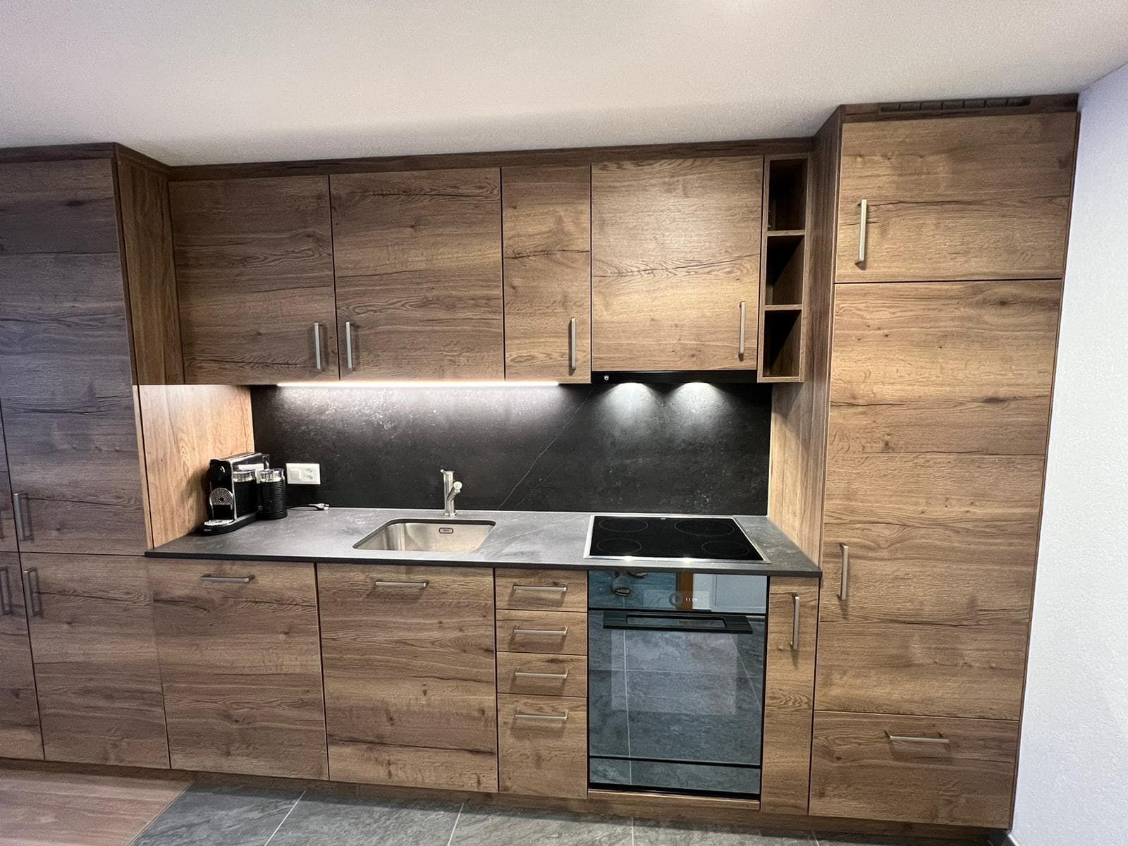 Küche des Studios mit Holzfronten, Herd und Backofen