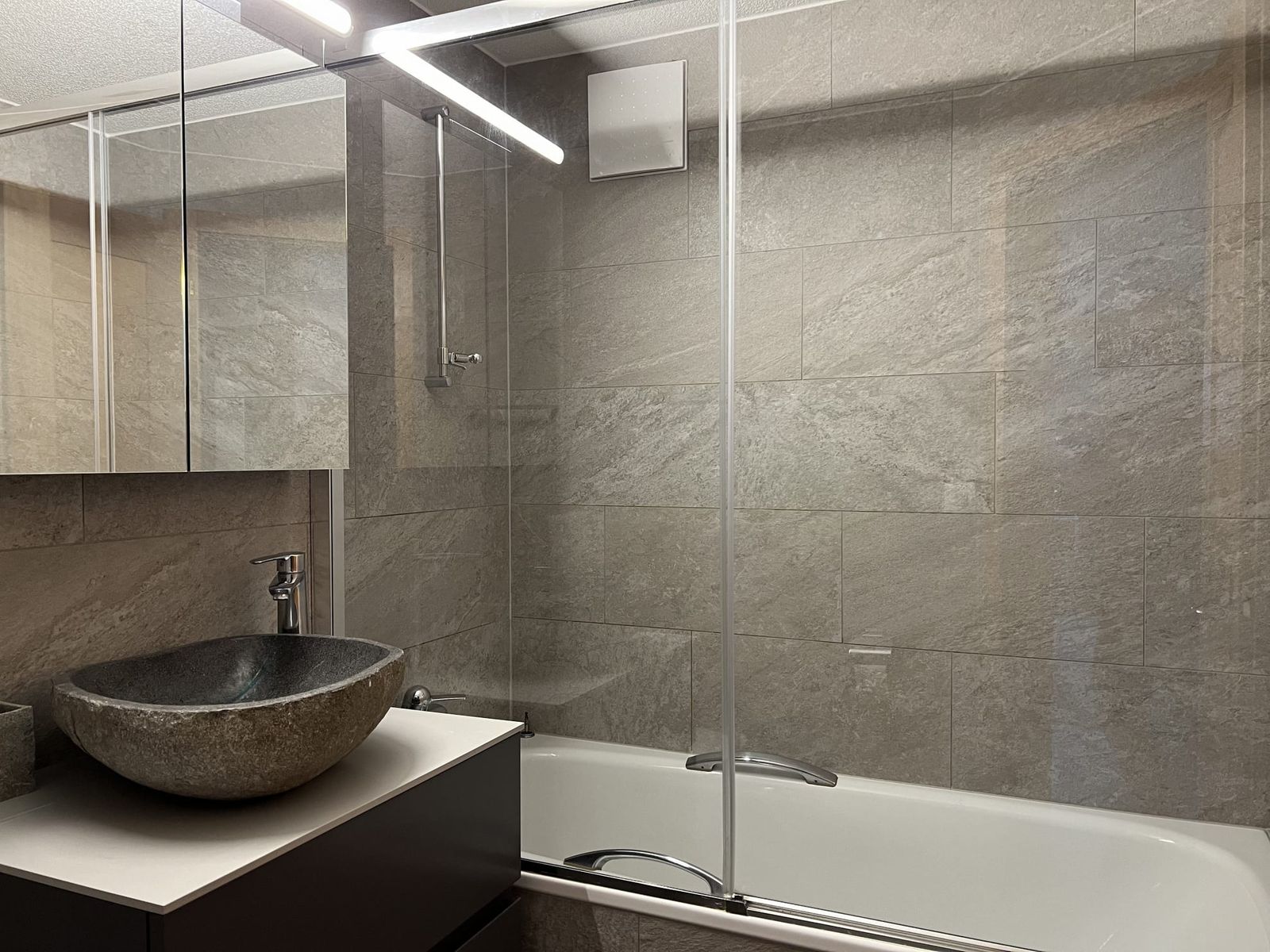 Bad des Apartments mit Steinbecken und Badewanne