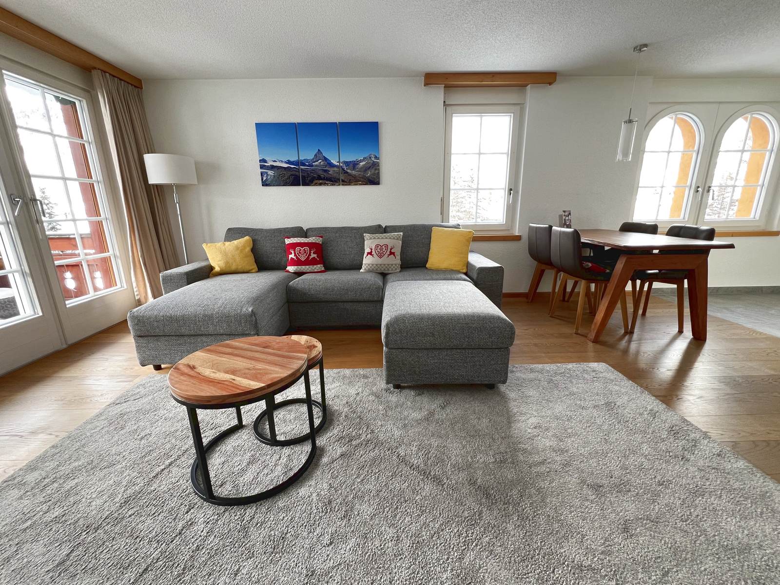 Wohnbereich des Apartments mit grauem Sofa und Teppich